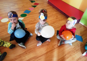 Dzieci siedzą z balonikami